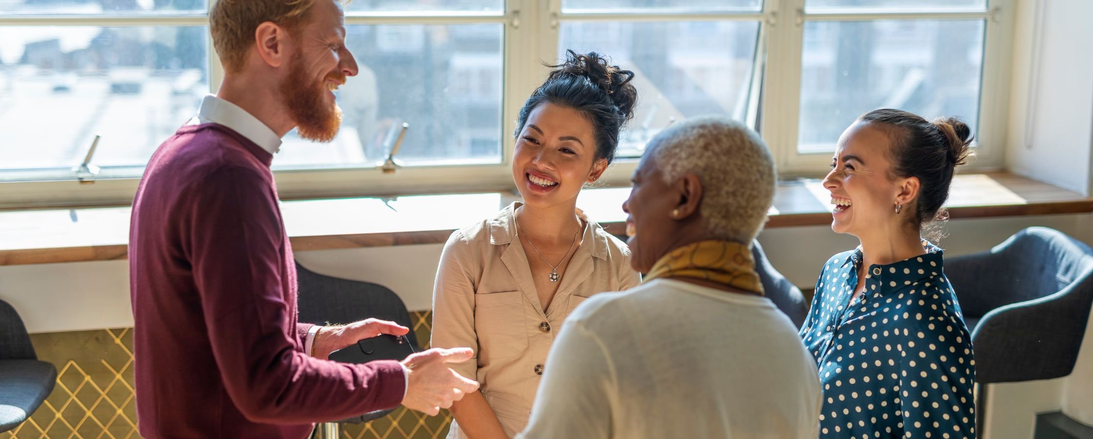 A happy man shares information with happy colleagues at a coworking space