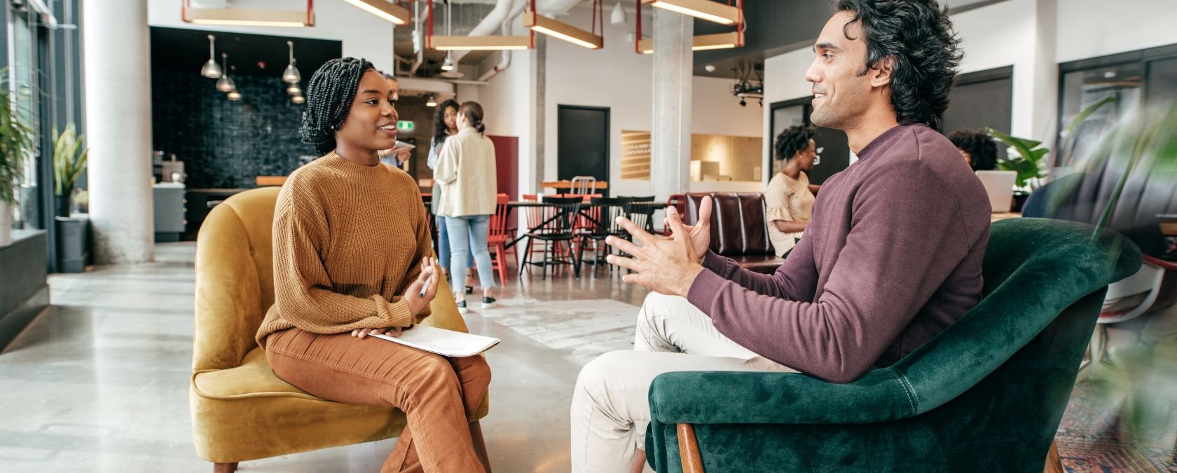 smiling young woman and friendly young man have a conversation in a coworking space