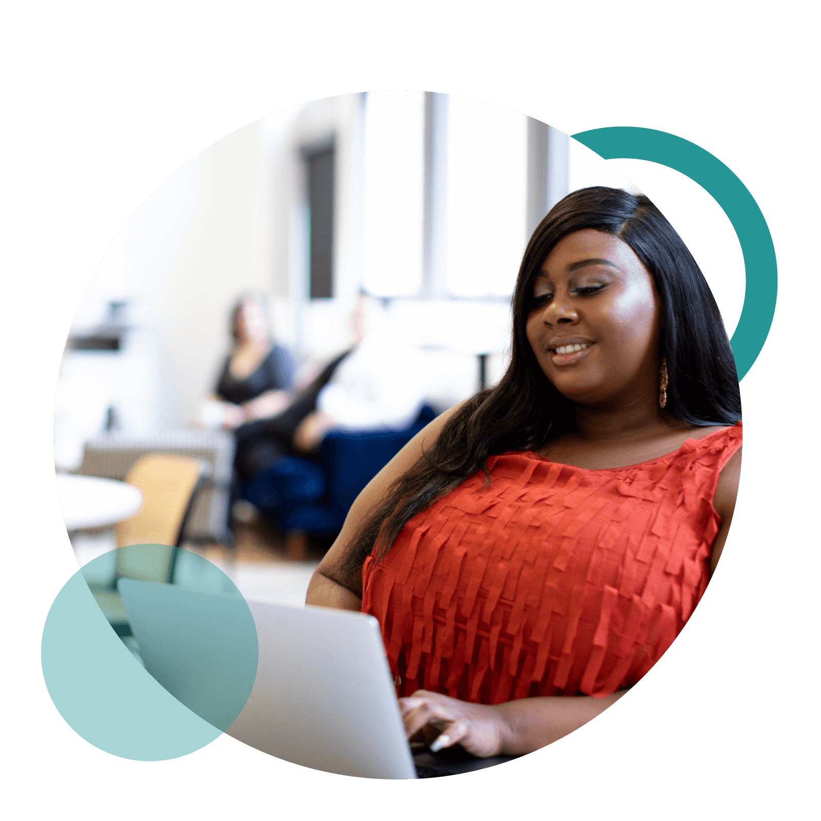 A woman looks at her laptop and smiles with coworkers in the background